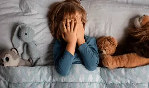 ילד שם 2 ידיים על העיניים כדי לישון