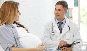 אישה הריונית מדברת עם רופא הנשים שלה