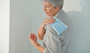 אישה שמה קרח על הכתף שלה