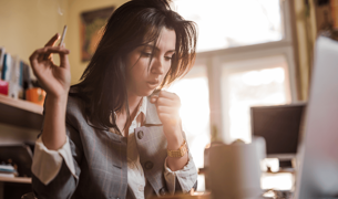 אישה מעשנת מול מחשב ומשתעלת