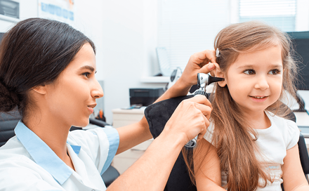 ילדה עוברת בדיקה באוזניים