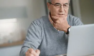 איש מבוגר מול מחשב מזמן תור לרופאה