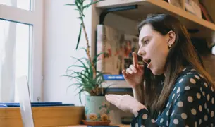 אישה צעירה חרשת משתמשת באתר ובאפליקציה המונגשים של לאומית