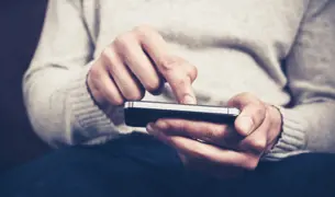 אצבע של אדם גולל בטלפון ומבקש שינפיקו לו טופס 17 דיגיטלי