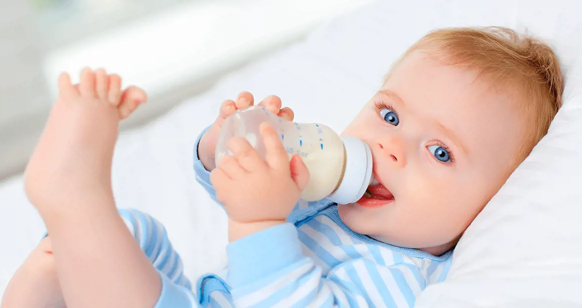 A baby drinks a bottle of milk