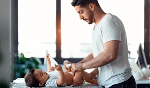 אבא מחליף טיטול לתינוק