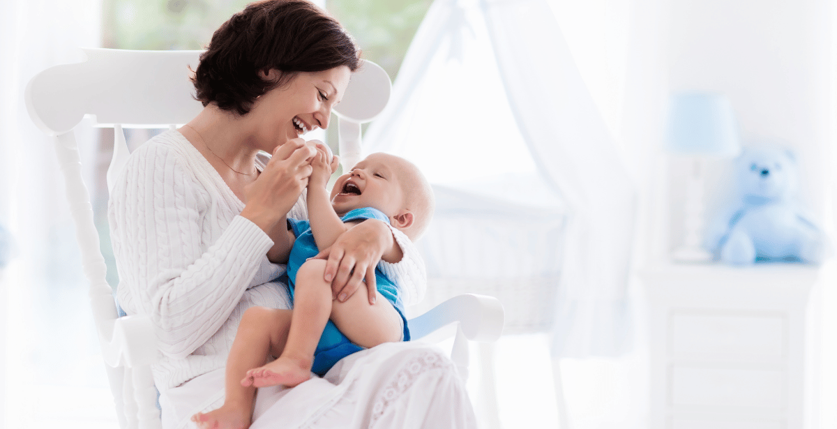 אמא טריה מחזיקה את התינוק שלה ומחייכת