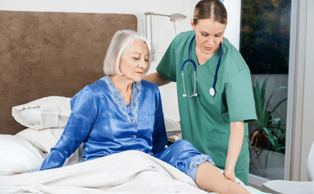 רופאה בודקת אישה מבוגרת, המאושפזת באשפוז ביתי