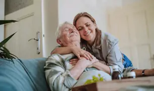 איש מבוגר על הספה מתחבק עם בת משפחתו