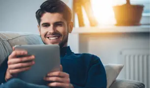 התכתבות, התייעצות, חידוש מרשמים עם הרופא האישי. גבר צעיר מתכתב עם הרופא בטבלט