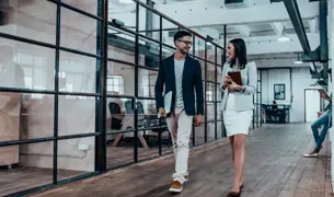 גבר ואישה הולכים ומדברים בתוך המשרד