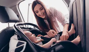 אמא חוגרת את התינוק בחגורה בבוסטר