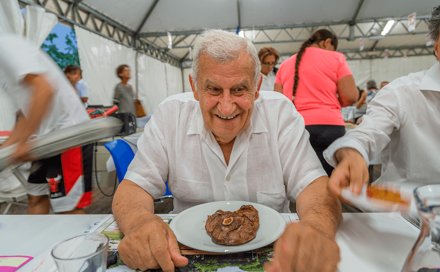 איש מבוגר אוכל סטייק בחדר האוכל