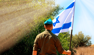 חייל מחזיק דגל ישראל ביד