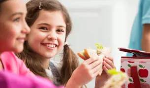 ילדה עם צמות אוכלת כריך