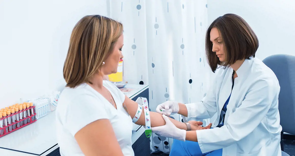 A woman measures a patient's blood