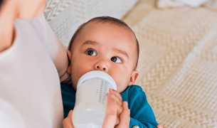 תינוקת בת 4 חודשים שותה חלב מבקבוק