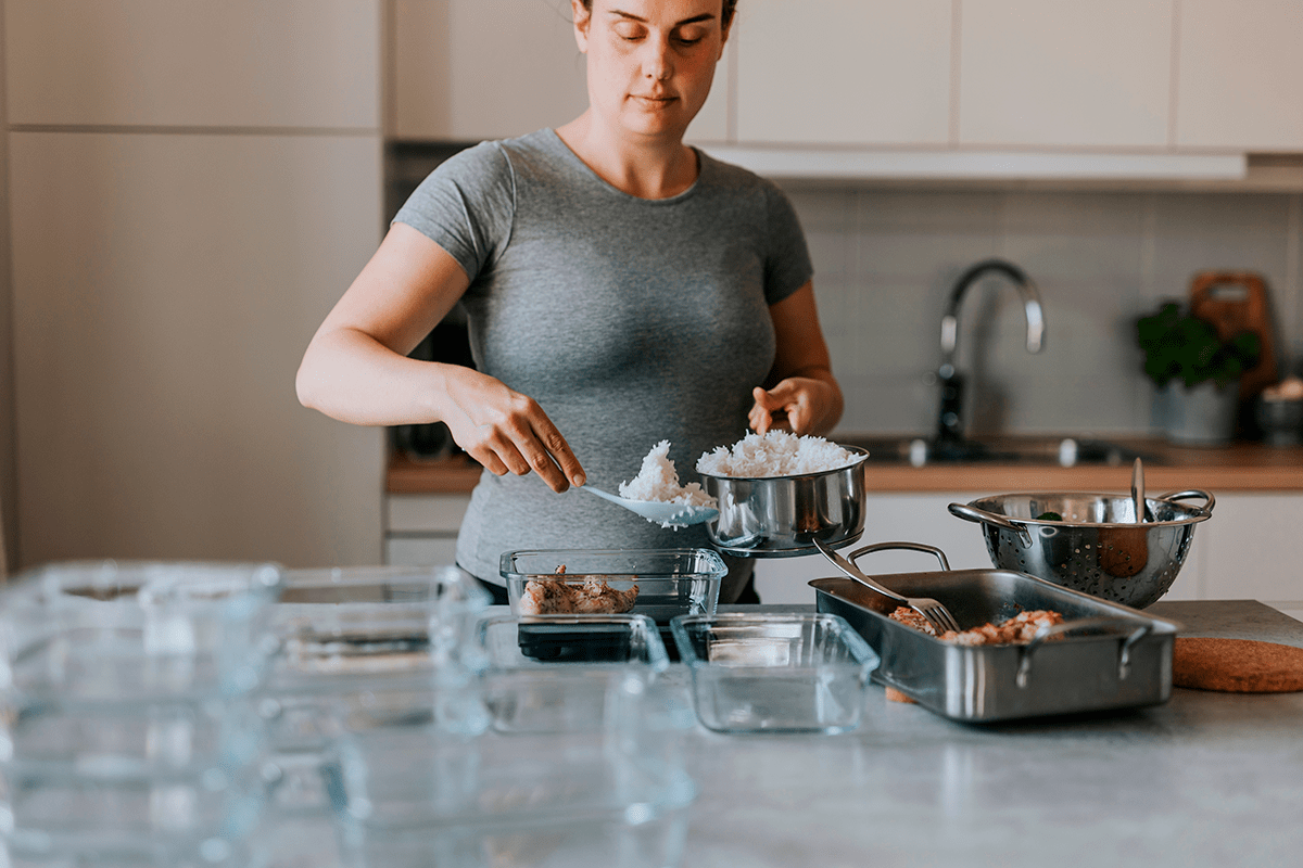A woman passes food from the pot