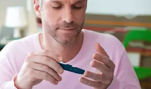 גבר בודק את רמות הסוכר שלו בדם