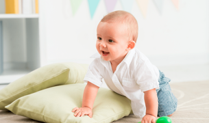 תינוקת בת 9 חודשים זוחלת עם רעשן ביד