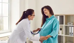 רופאה בודקת אישה הריונית בכחול