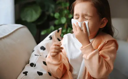 A girl blows her nose