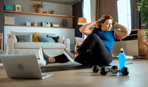 אישה מלאה עושה כושר בבית