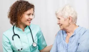 אחות בלאומית מחבקת ותומכת באישה מבוגרת