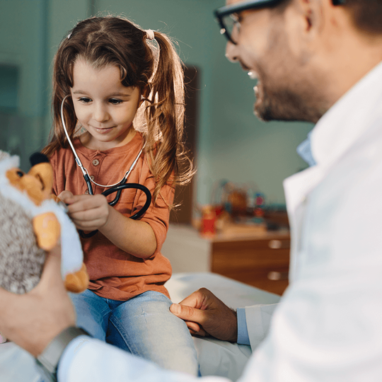 רופא ילדים משחק עם ילדה קטנה